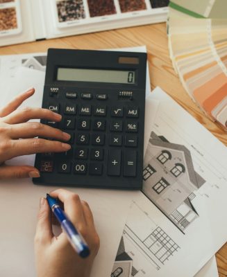 Woman making estimate, using calculator and house project.